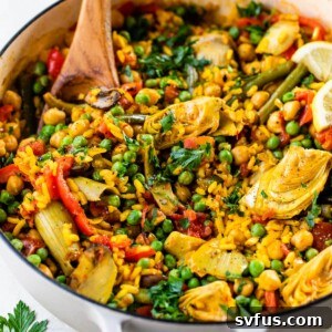 vegetable paella in a dutch oven with a wooden spoon