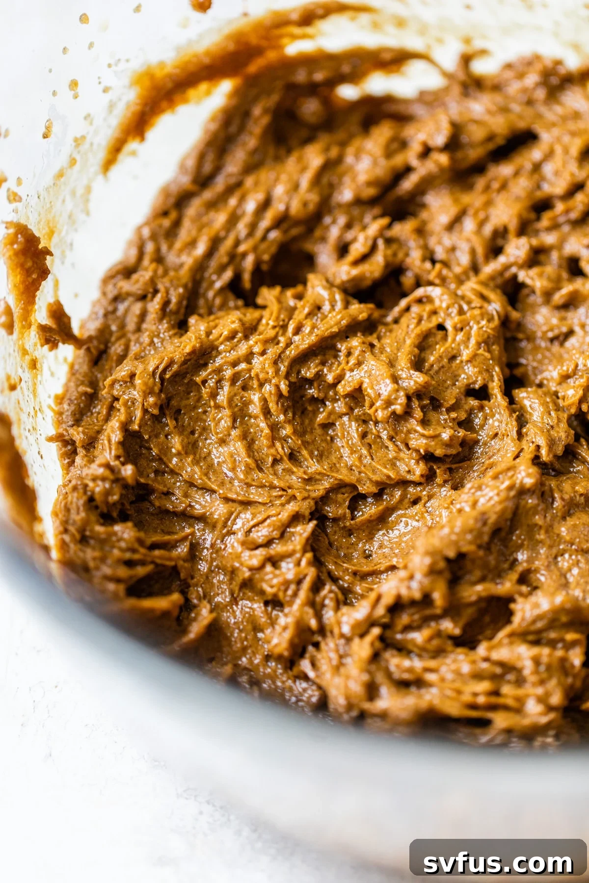 Smooth molasses cookie dough in a clear glass bowl, ready for dry ingredients