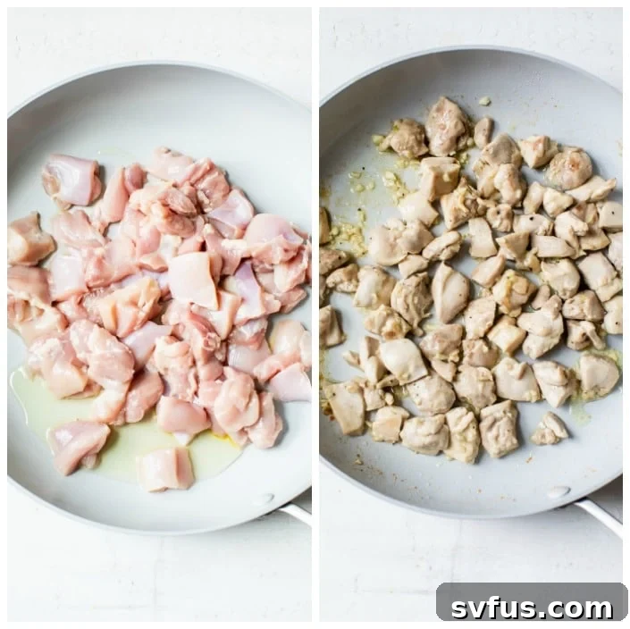 Diced chicken pieces cooking in a large skillet with olive oil, browning lightly.