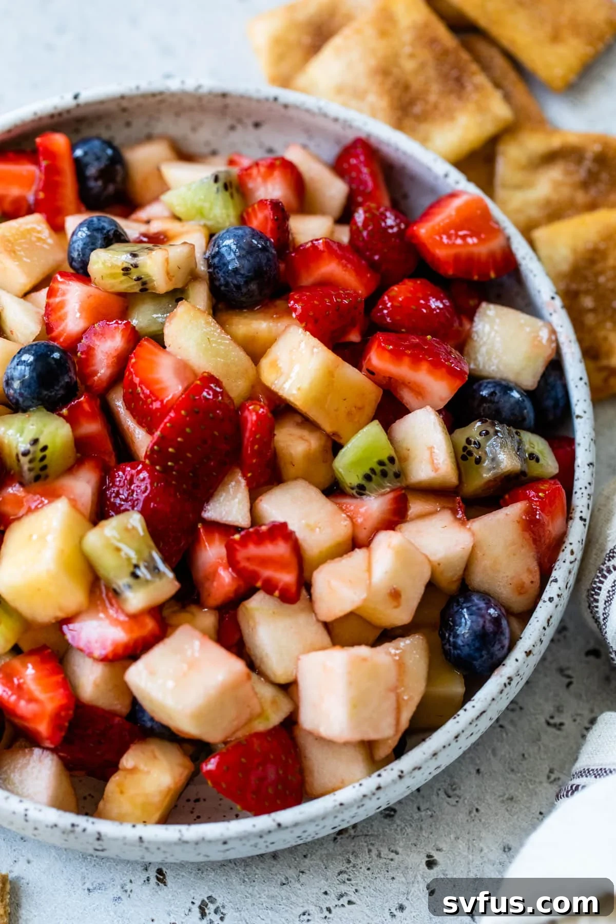 close-up of fruit salsa in a bowl with graham crackers and cinnamon pita chips off to the side