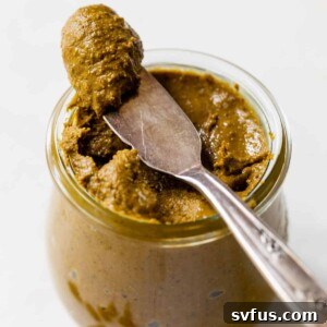 pistachio butter in a jar with a small amount on a knife