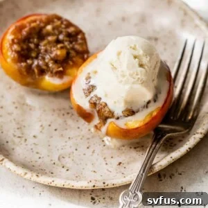 baked peaches on a plate with a fork and a scoop of vanilla ice cream on top