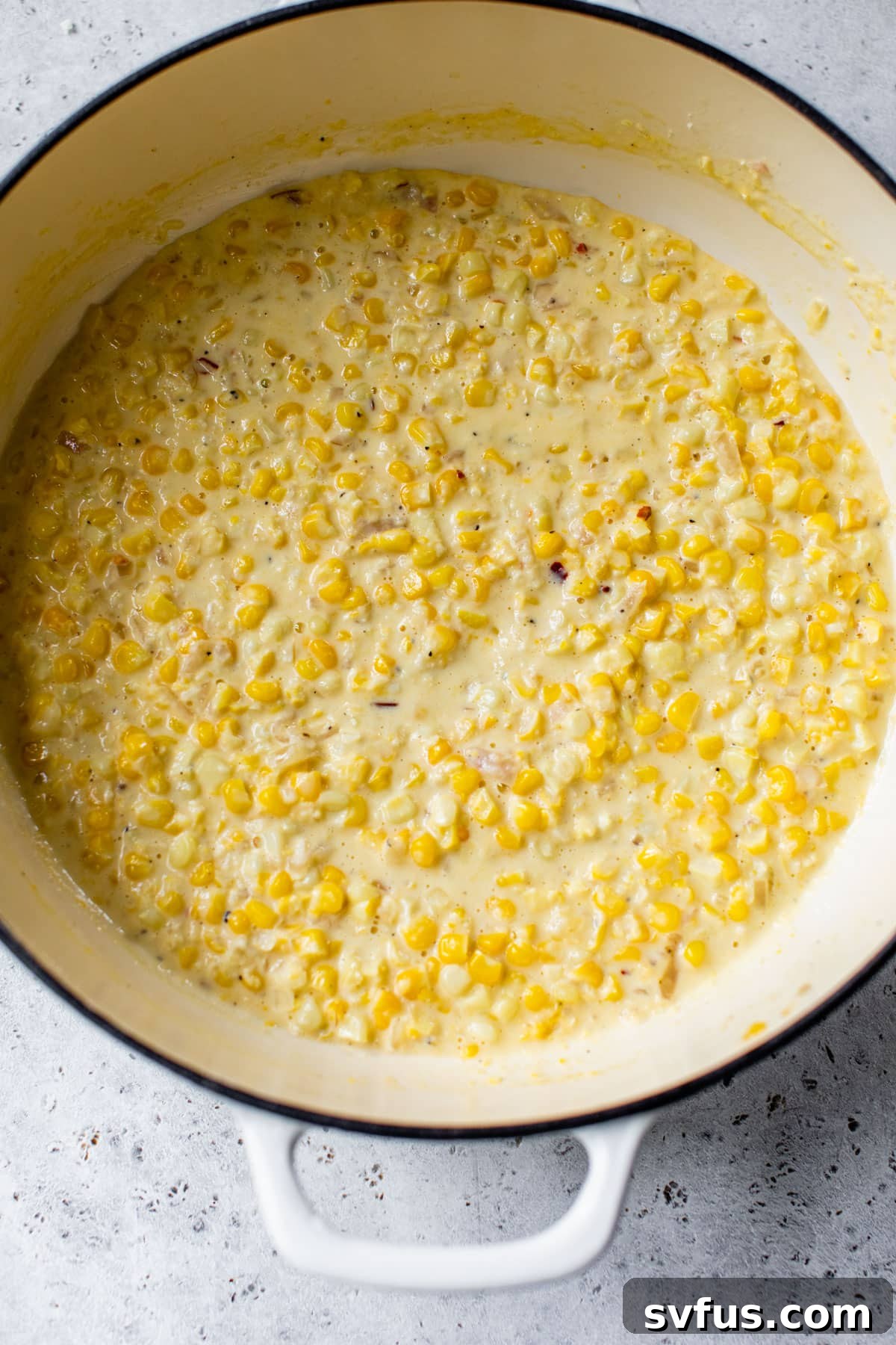 Melted butter, sautéed shallot, aromatic garlic, and sweet corn in a Dutch oven, forming the base of a delicious sauce.