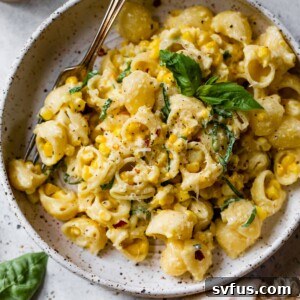 A beautifully plated bowl of creamy corn pasta, garnished with fresh basil, ready to be enjoyed.