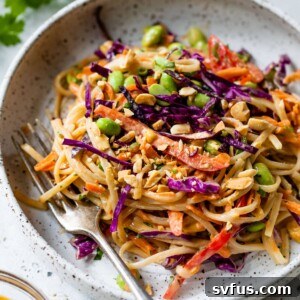 thai noodle salad on a plate with a fork and peanuts on top