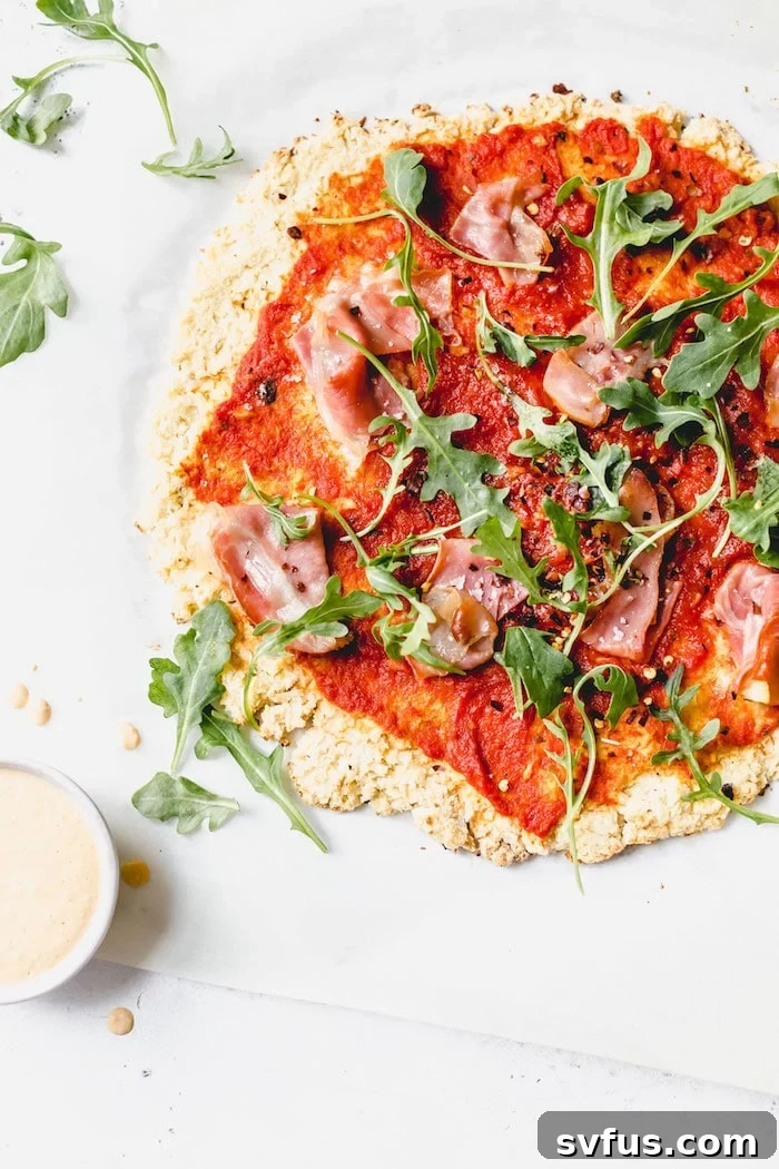 Delicious Whole30 pizza with a crispy cauliflower crust, topped with prosciutto and fresh arugula, perfect for a healthy pizza night.