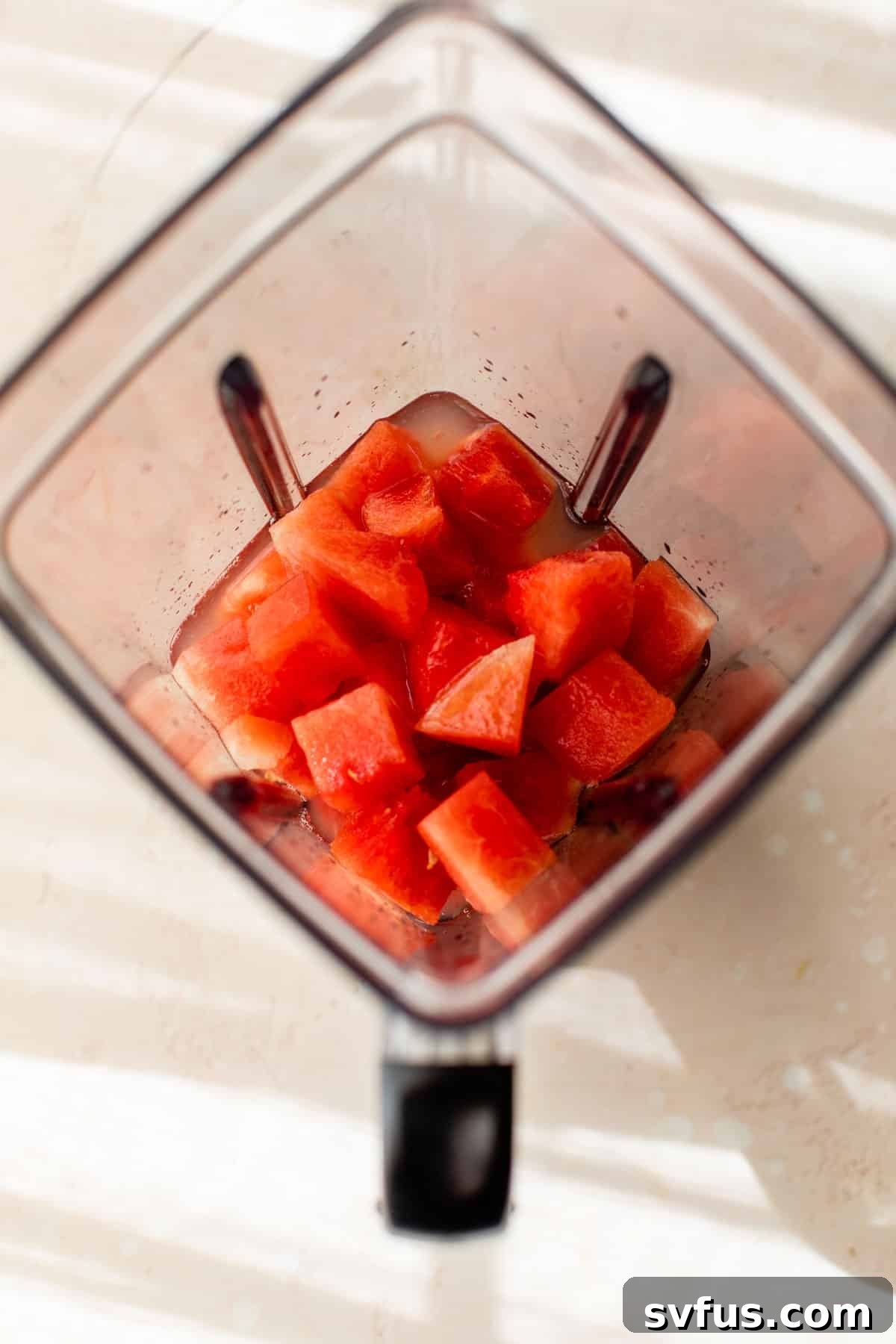 cubed watermelon added to a blender