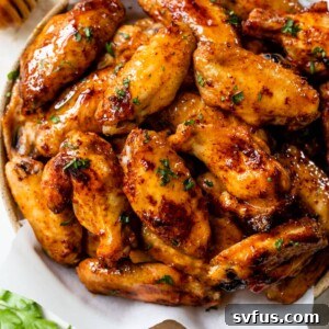 hot honey chicken wings stacked on top of a plate