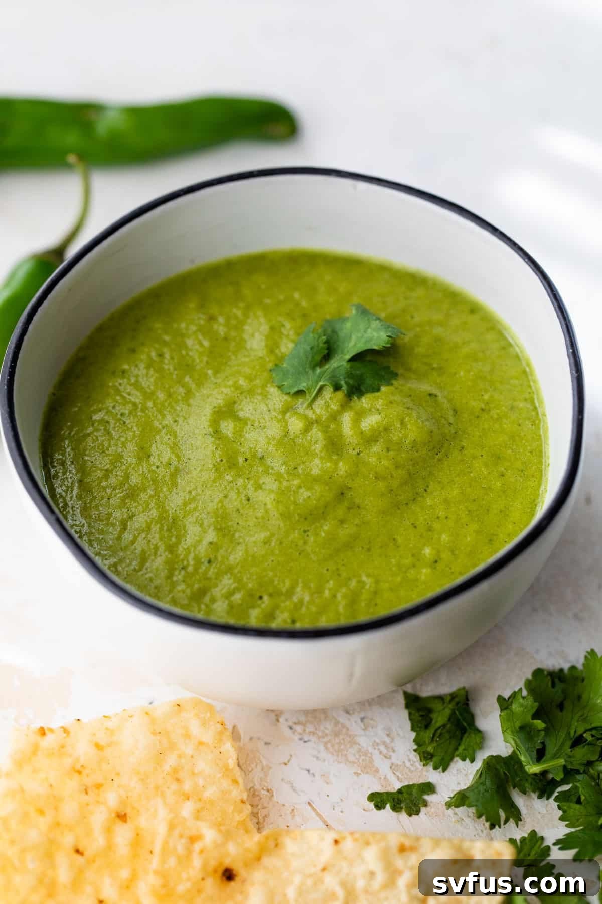 Vibrant green serrano salsa in a bowl, garnished with fresh cilantro, ready to be served.