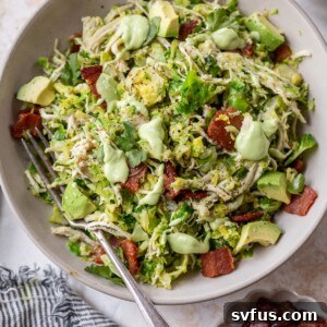 chicken brussels sprouts salad in a bowl with a fork