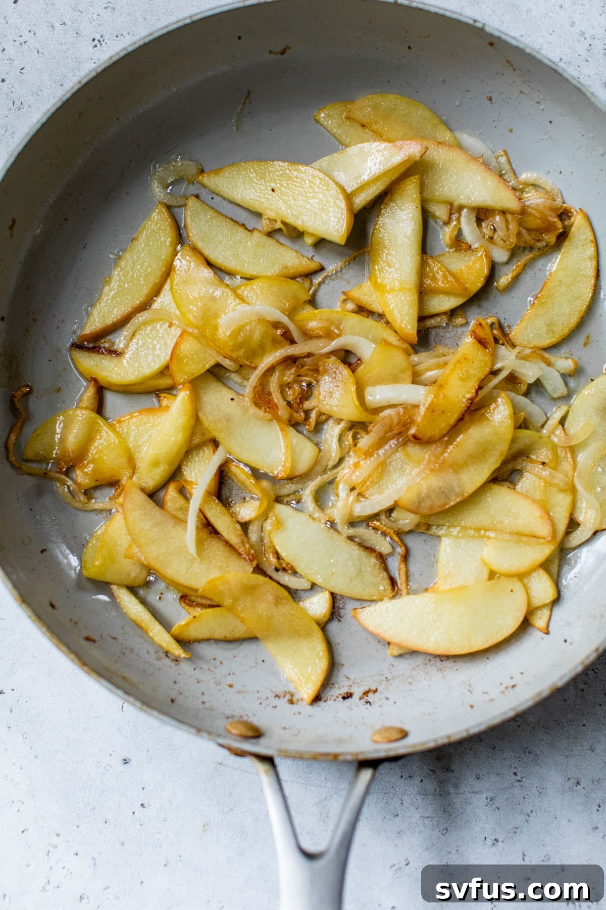 sliced apples and onion cooking in a skillet