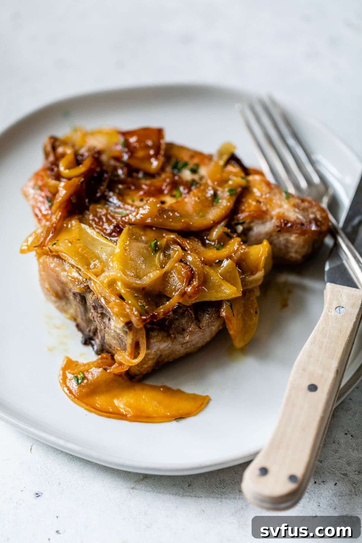 apple pork chops on a plate with a knife and fork