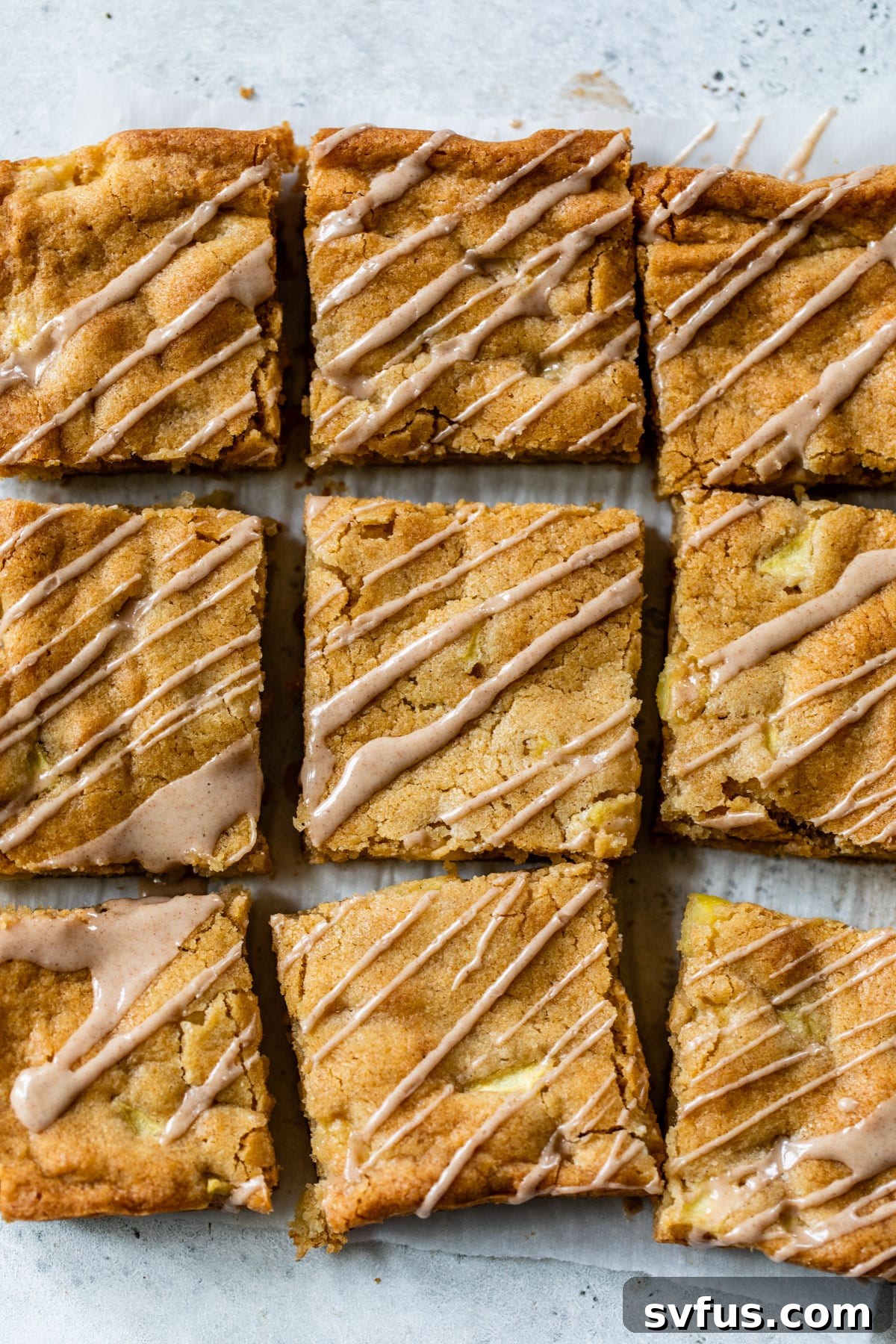 Beautifully sliced apple blondies arranged on a serving plate, each bar generously adorned with a sweet cinnamon glaze.
