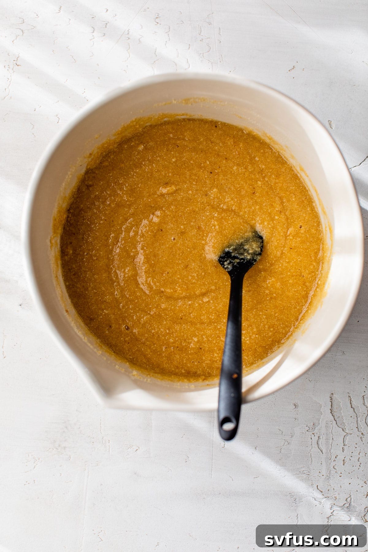 Vanilla cupcake batter in a mixing bowl, showcasing its smooth and thick texture before baking.