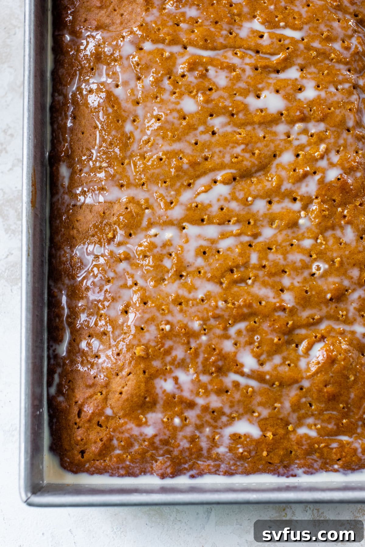 baked cake with poked holes in it and the 3 milks poured overtop