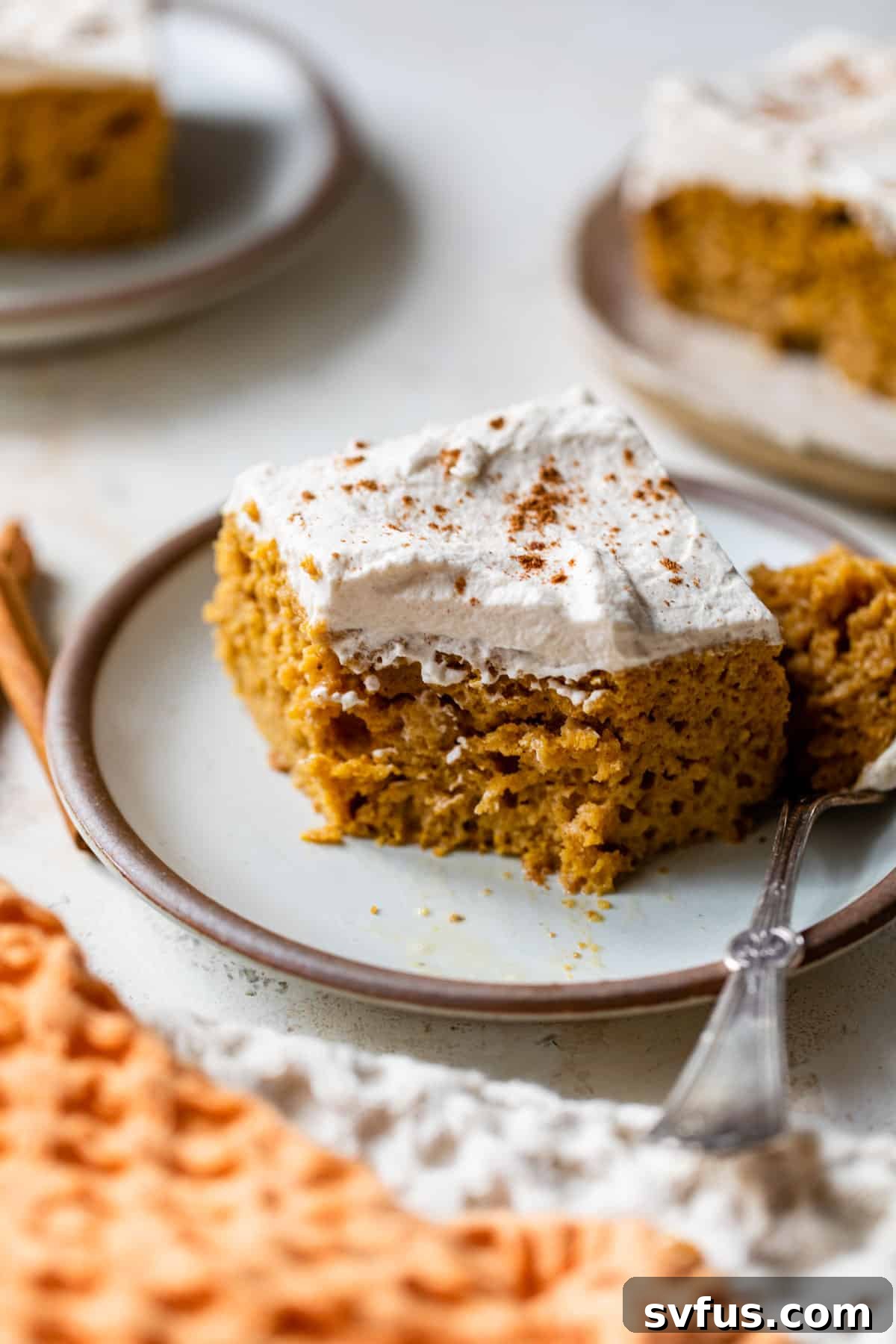 a slice of pumpkin tres leches on a plate with a fork and a bite taken out