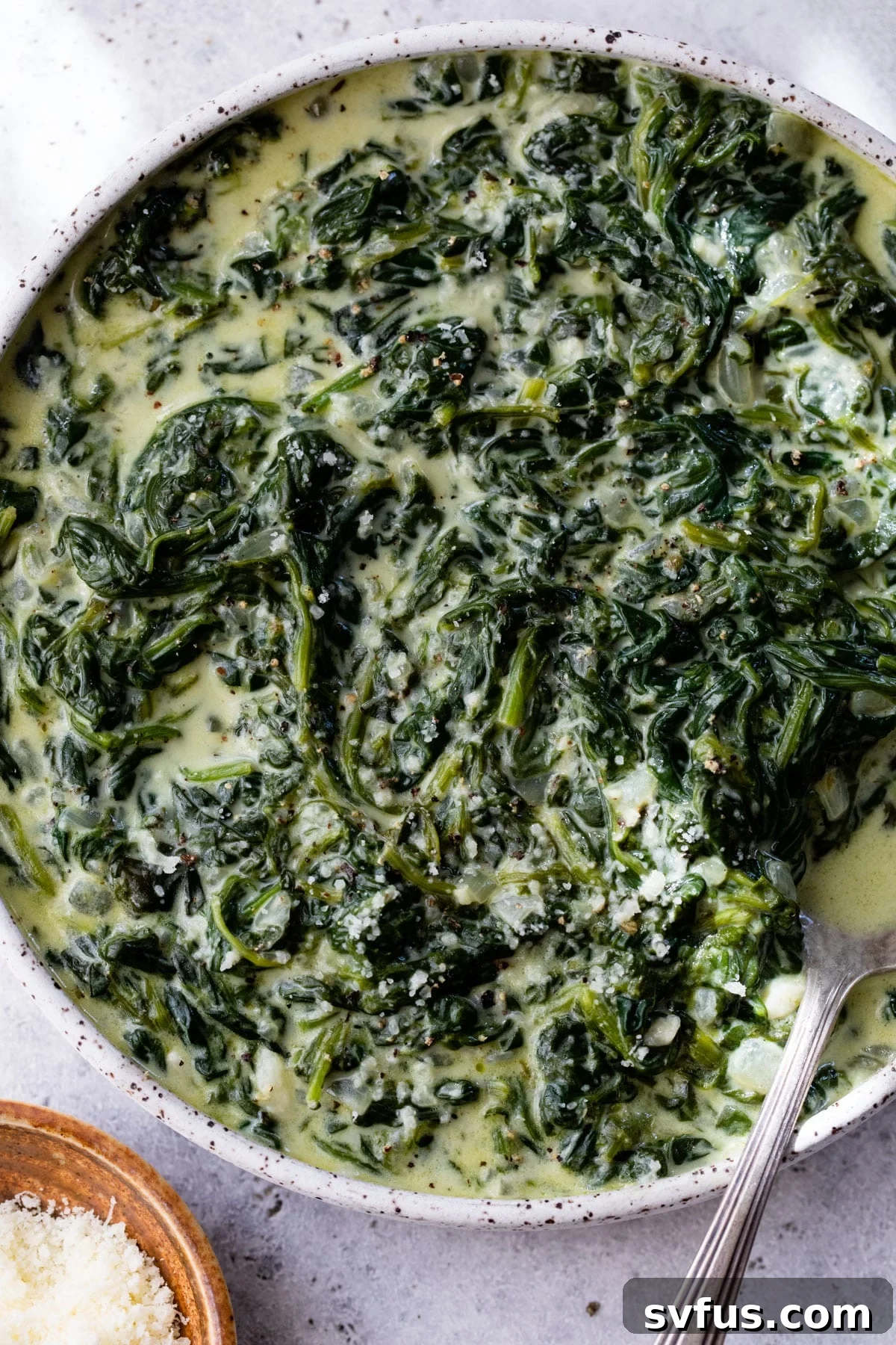 creamed spinach in a bowl with a spoon, ready to be enjoyed