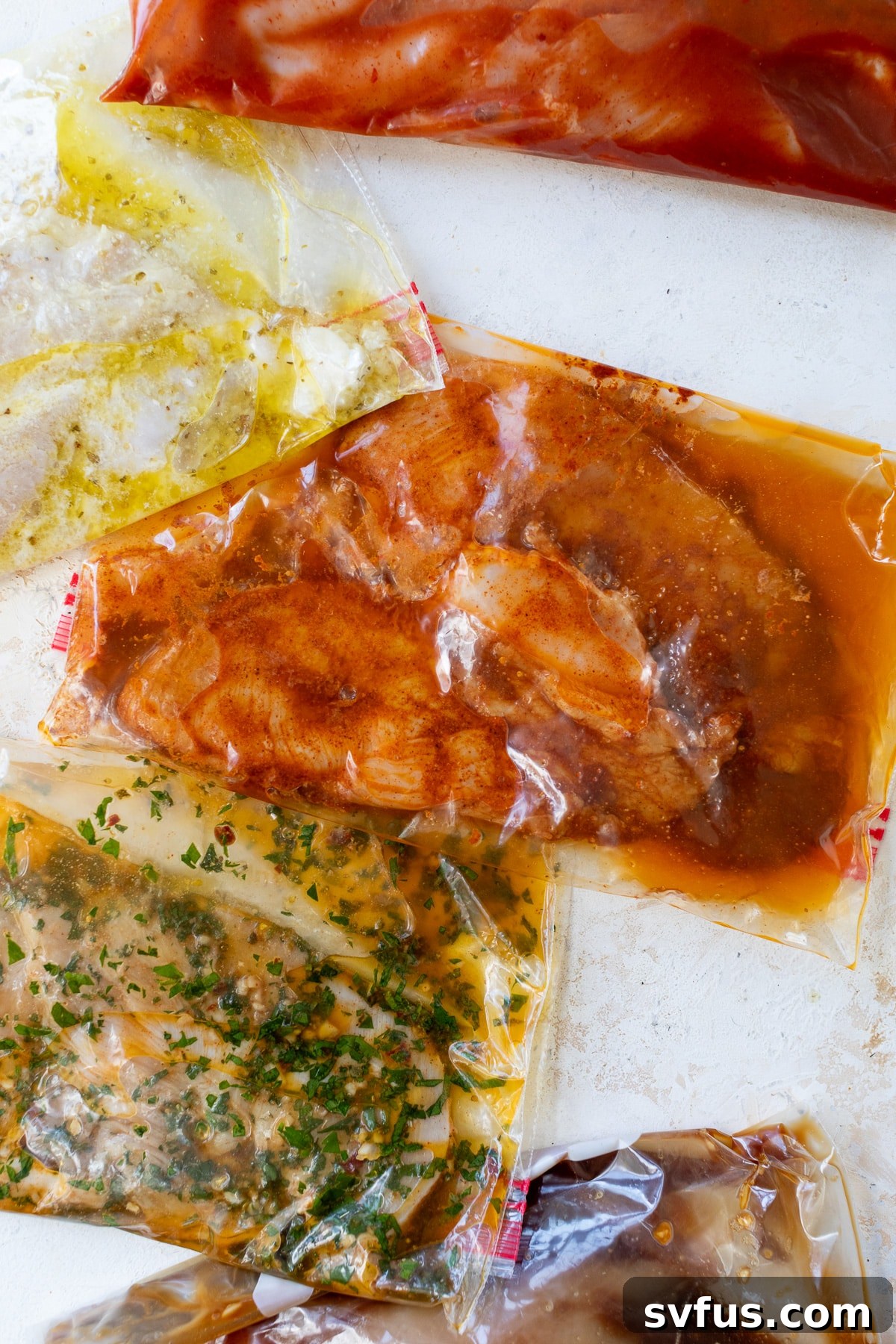 A close-up view of all five chicken marinades in their sealed plastic bags, neatly arranged and ready for refrigeration or freezing.
