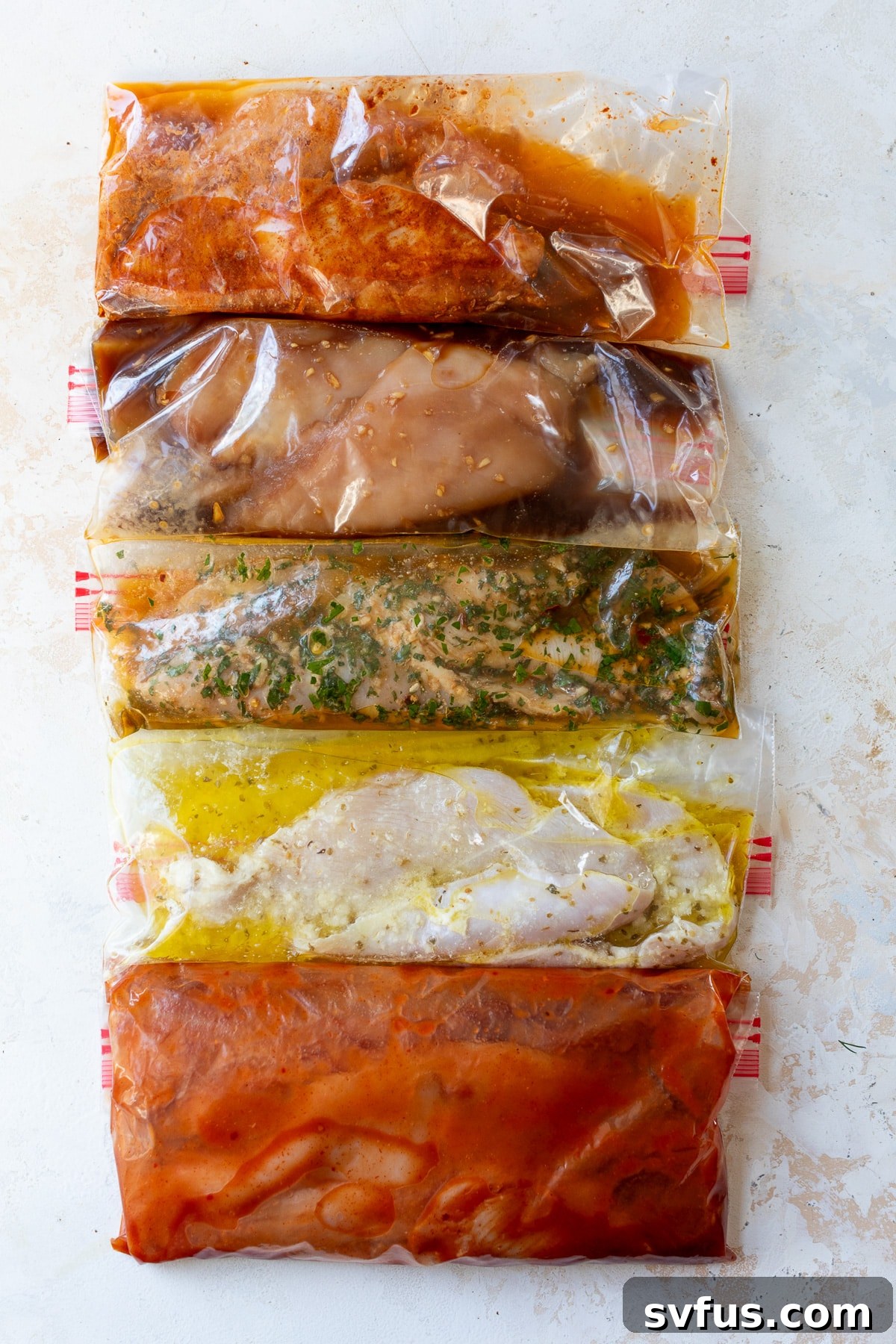 A vibrant display of all five types of marinated chicken, each in its own plastic bag, showcasing their rich colors and readiness for cooking.