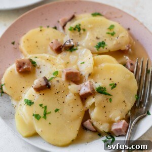 scalloped potatoes and ham on a plate with a fork
