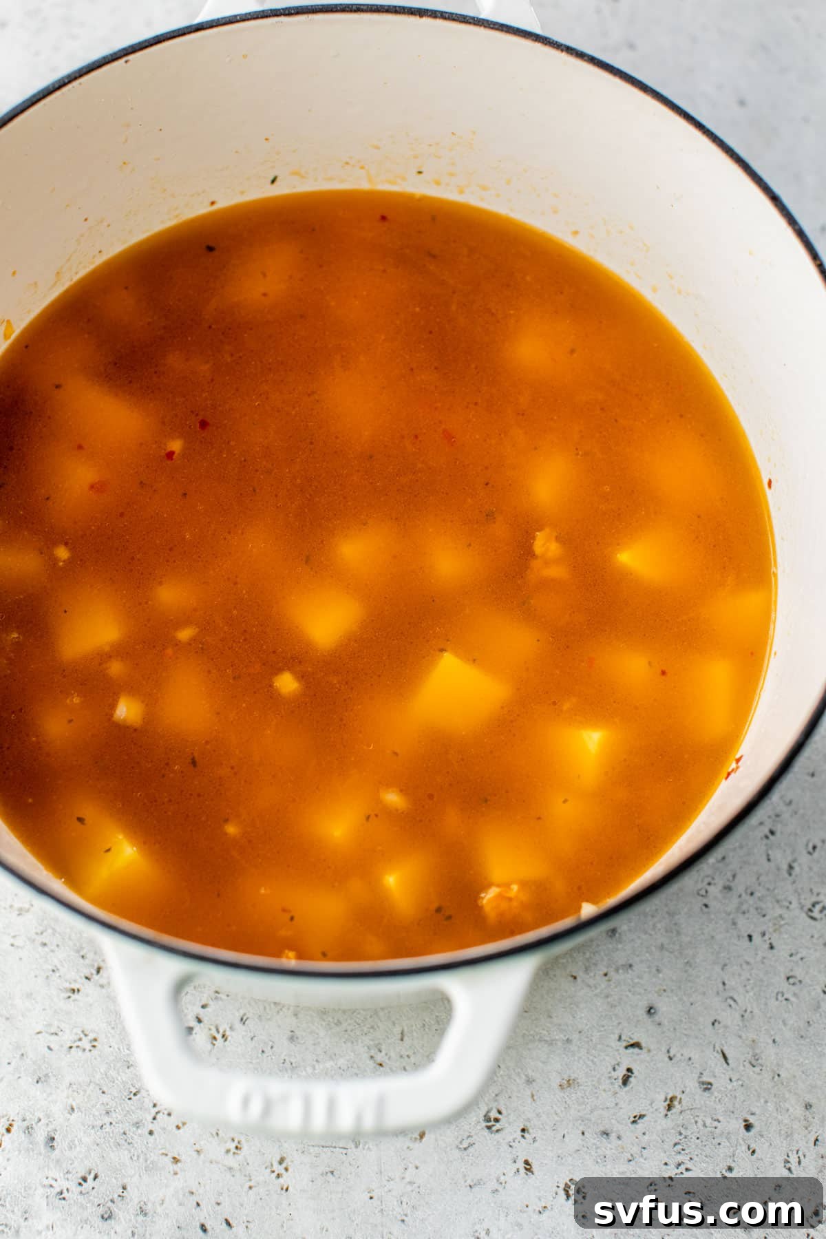 Diced potatoes and chicken broth added to the Dutch oven, gently simmering.