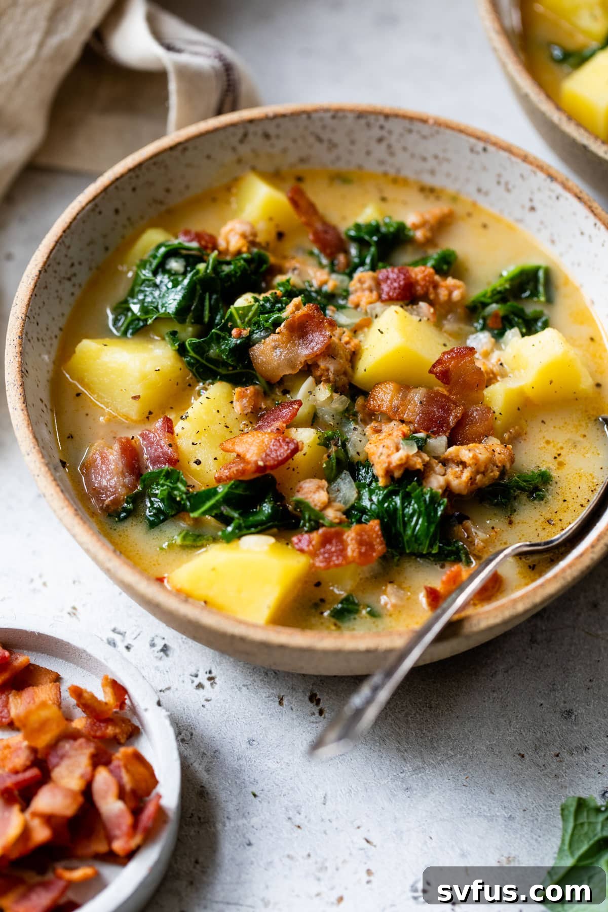 A bowl of Whole30 Zuppa Toscana with a spoon, perfectly garnished and ready for serving.