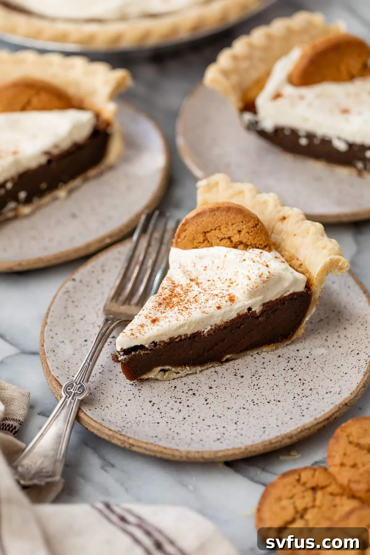A single slice of gingerbread pie on a white plate with a fork resting beside it, ready to be enjoyed.