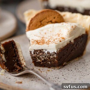 A slice of gingerbread pie with a bite taken out on a plate