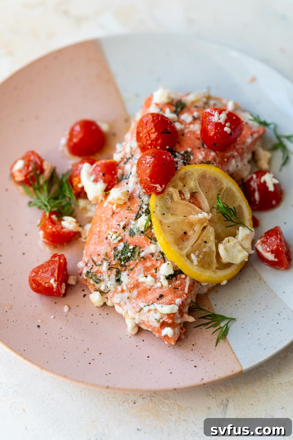 greek salmon on a plate with a lemon slice