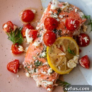greek salmon on a plate with a lemon slice
