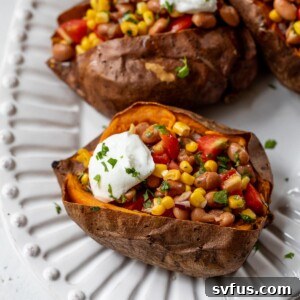 close-up of vegan stuffed sweet potatoes on a plate topped with sour cream