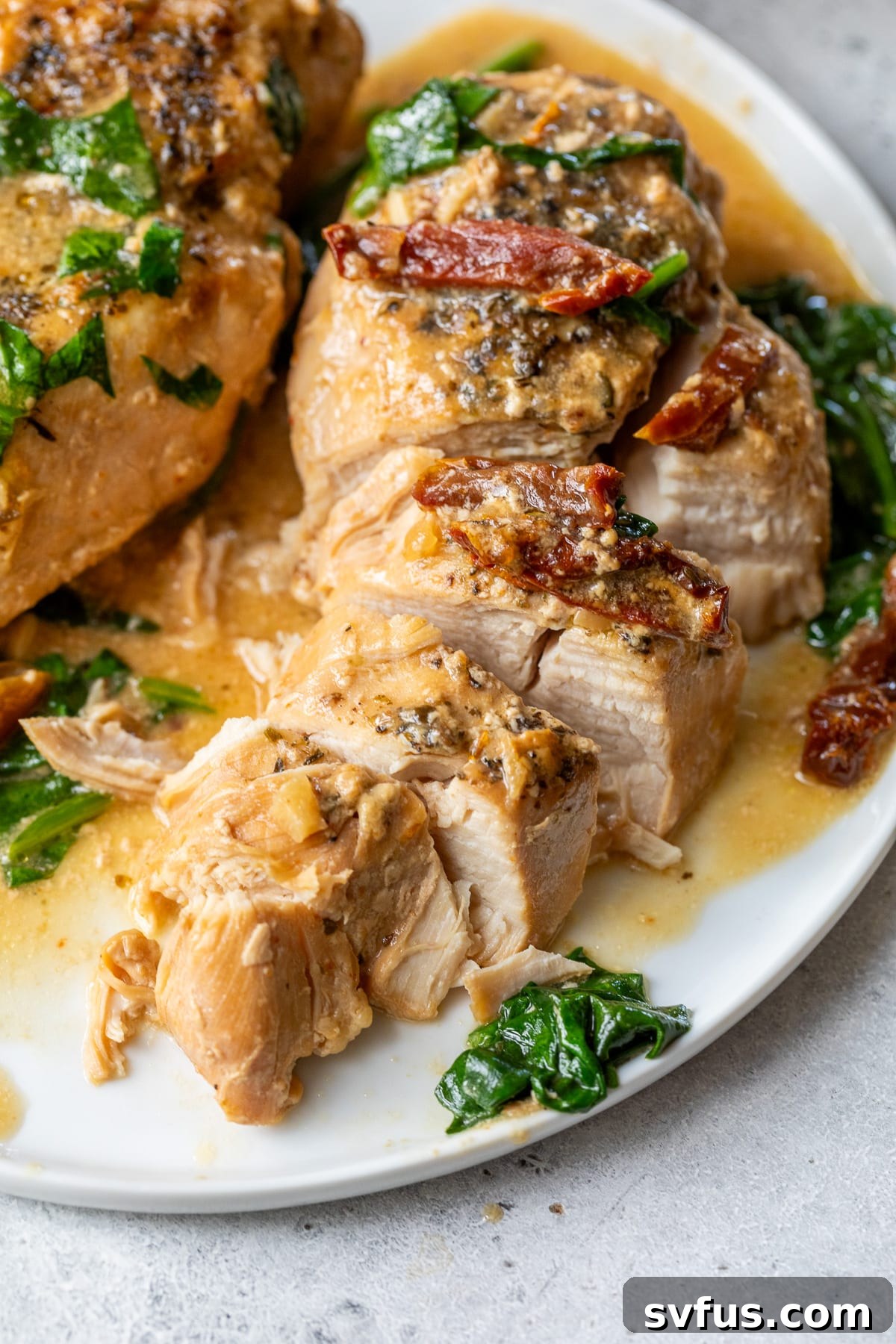 crockpot tuscan chicken on a plate sliced with a knife