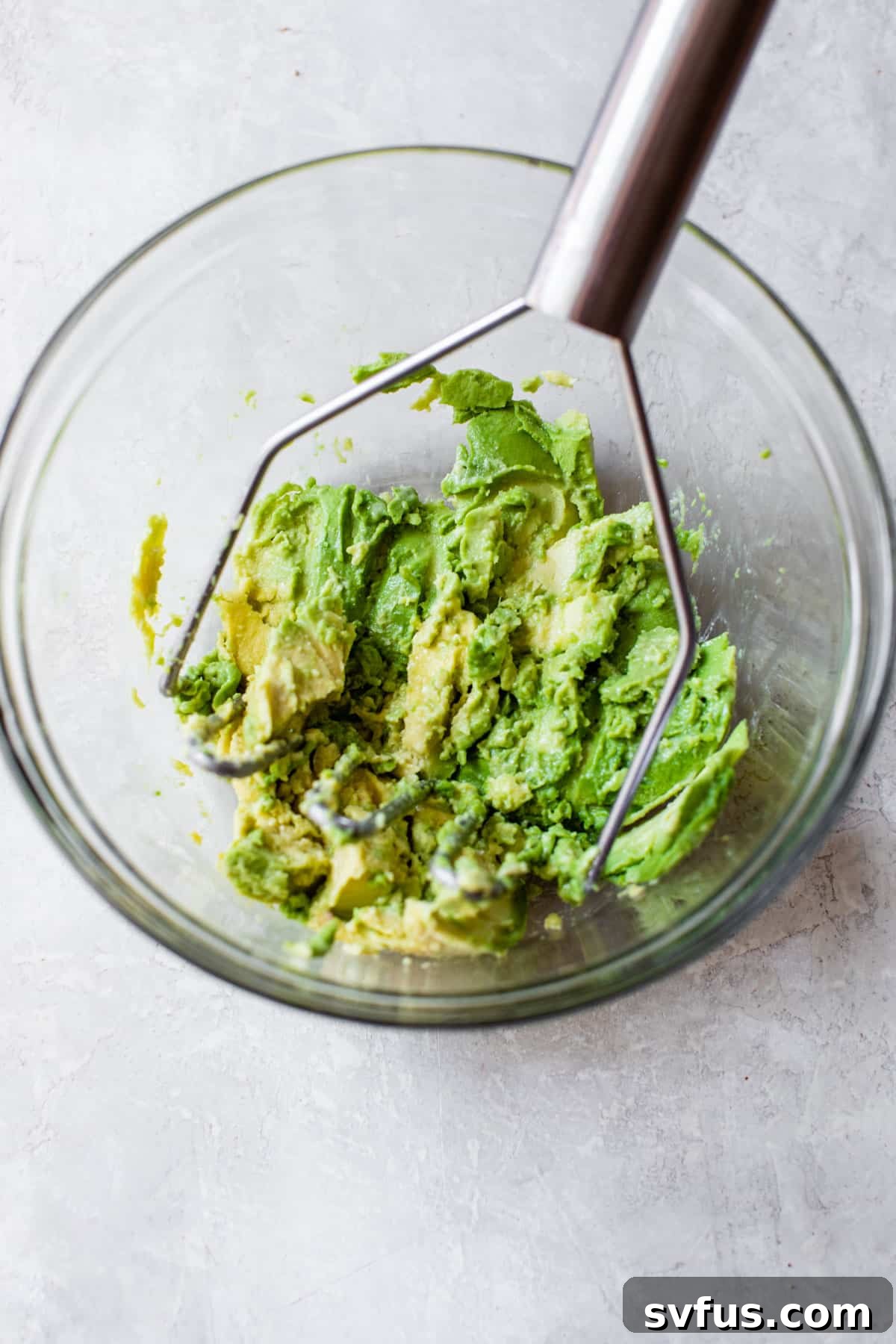 mashed avocado in a glass bowl