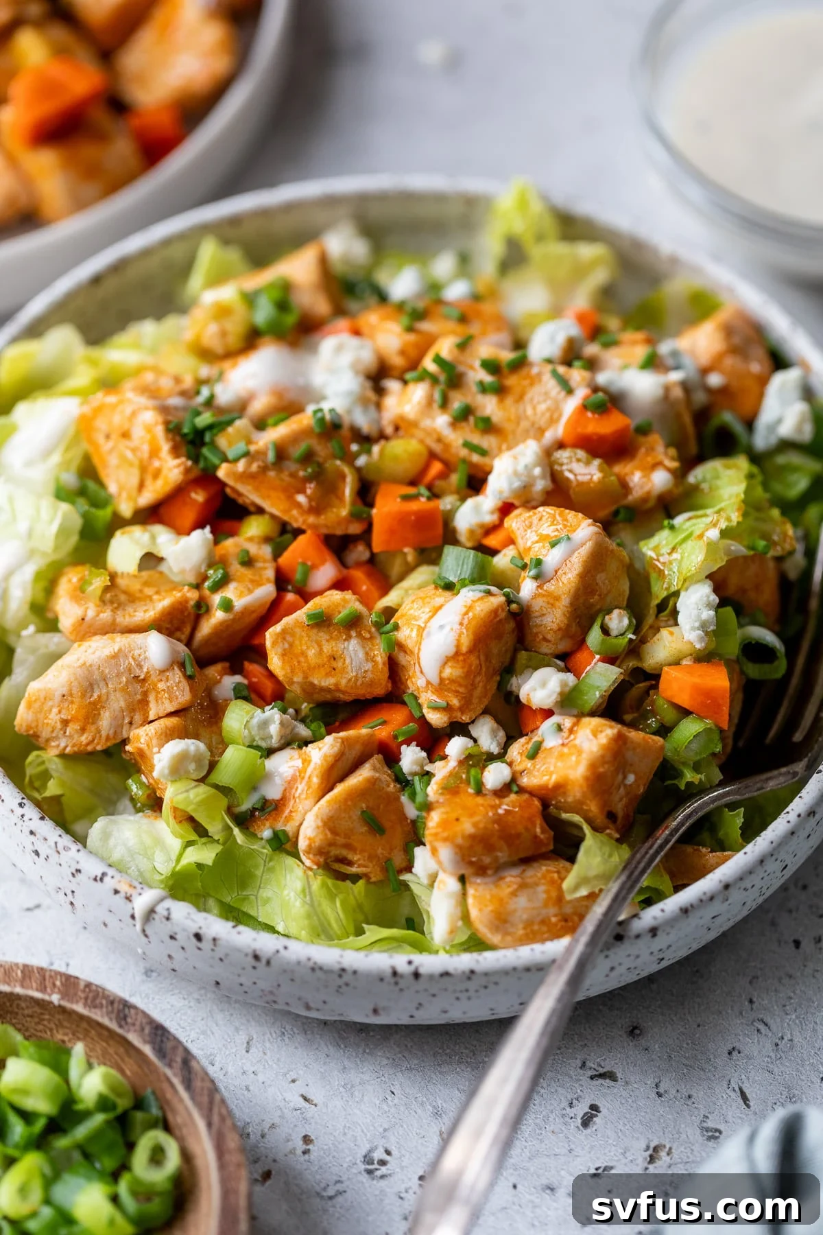 A bowl of healthy Buffalo Chicken Salad with a fork, ready to eat