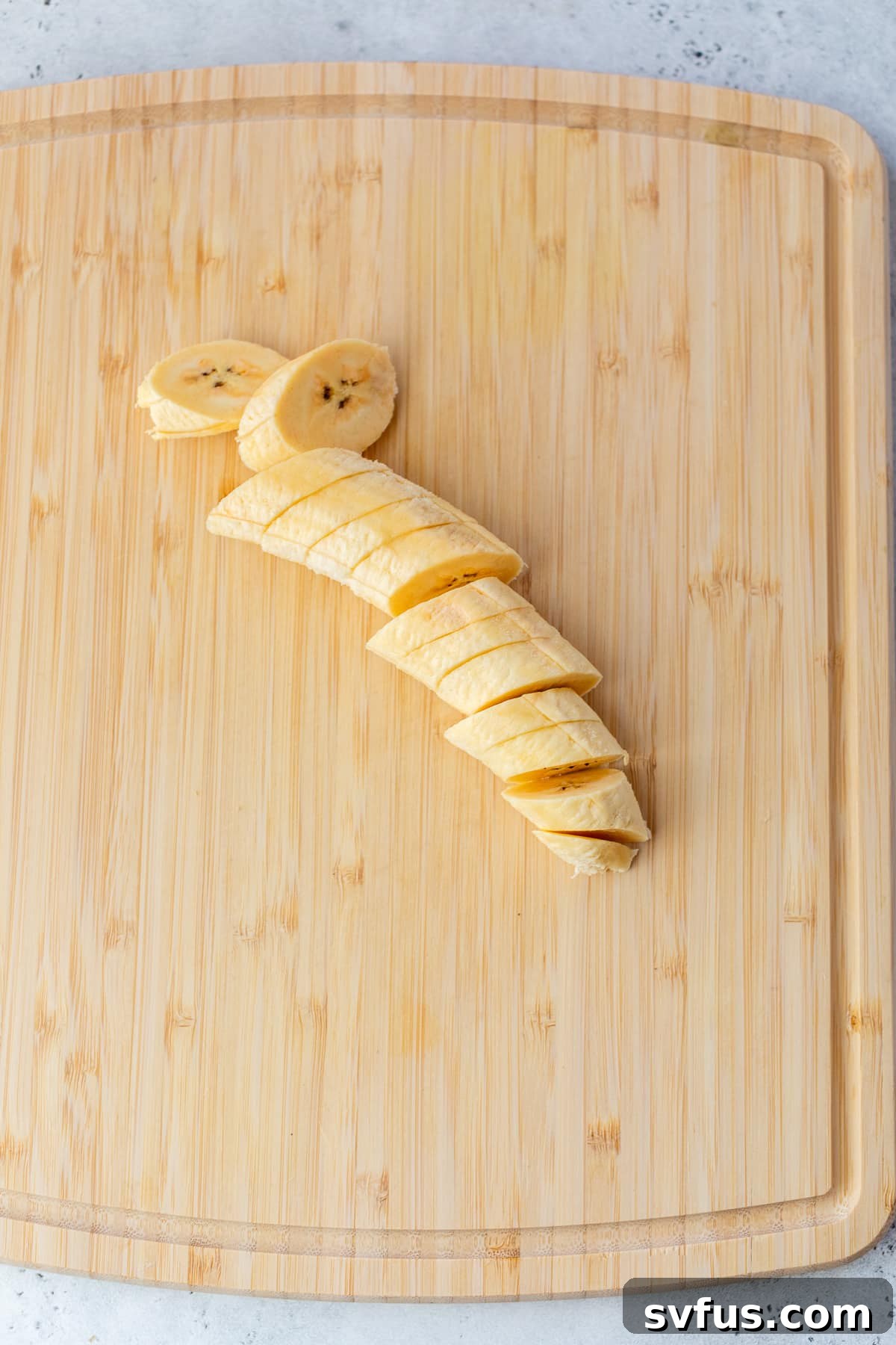 a plantain sliced into pieces on a cutting board