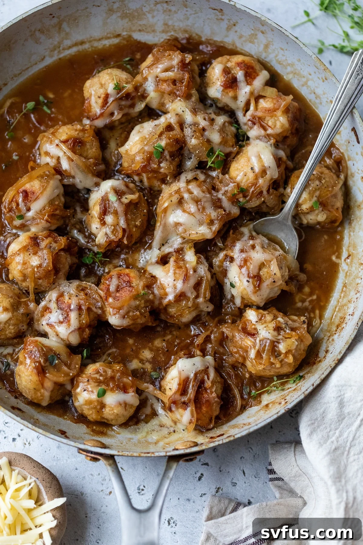 french onion chicken meatballs in a skillet with a spoon