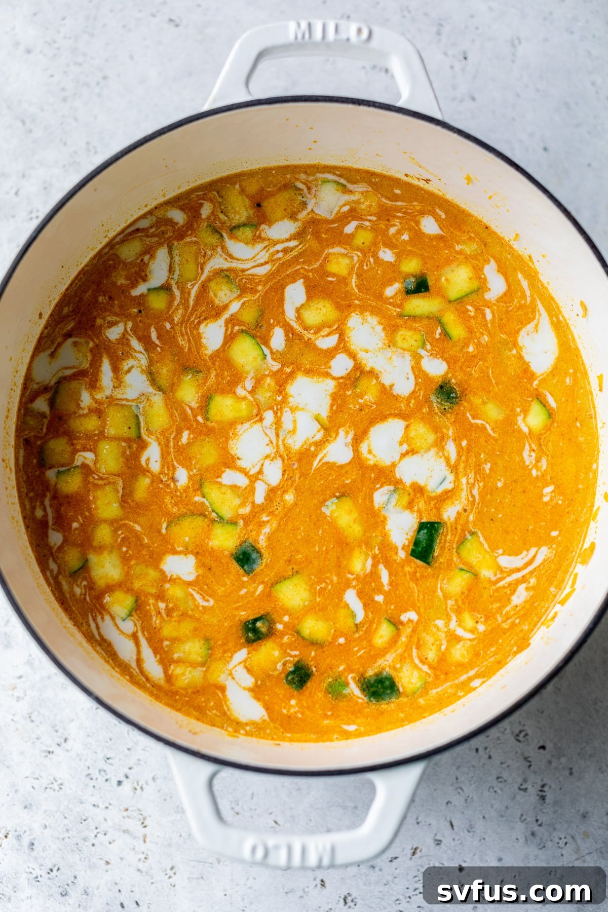 coconut milk added to the soup in a dutch oven