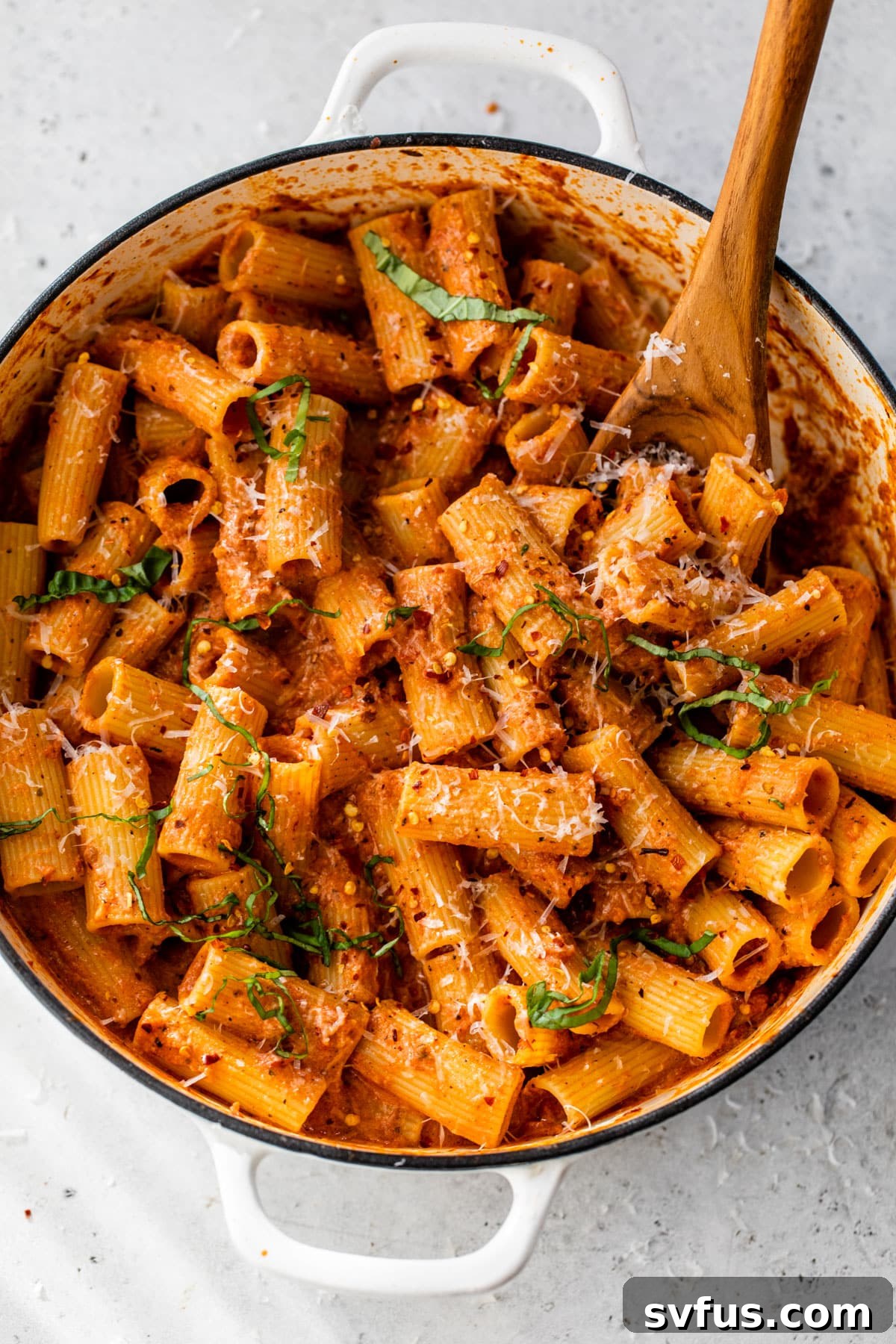 vodka rigatoni in a dutch oven with a wooden spoon