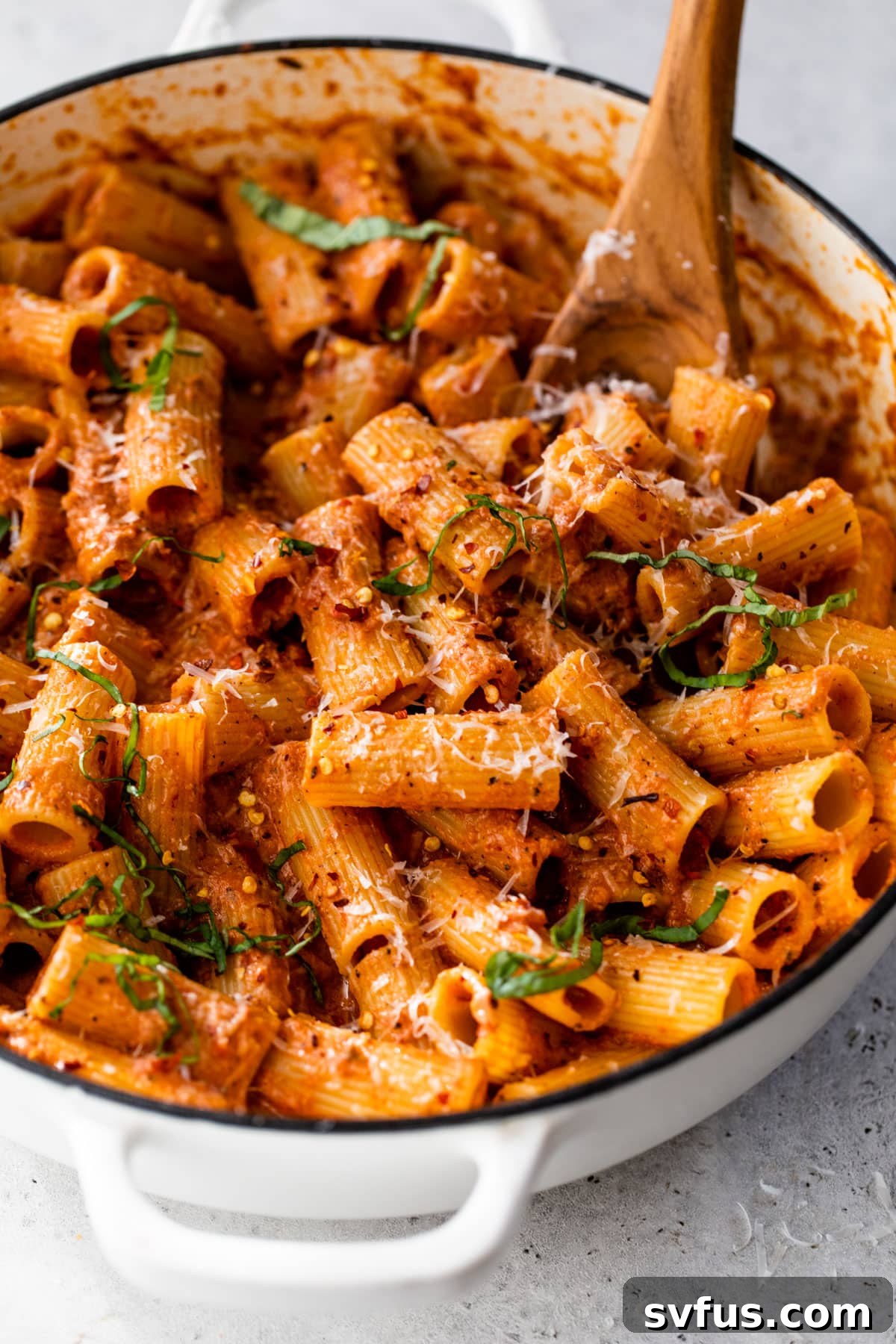 close-up of vodka rigatoni in a dutch oven with a wooden spoon