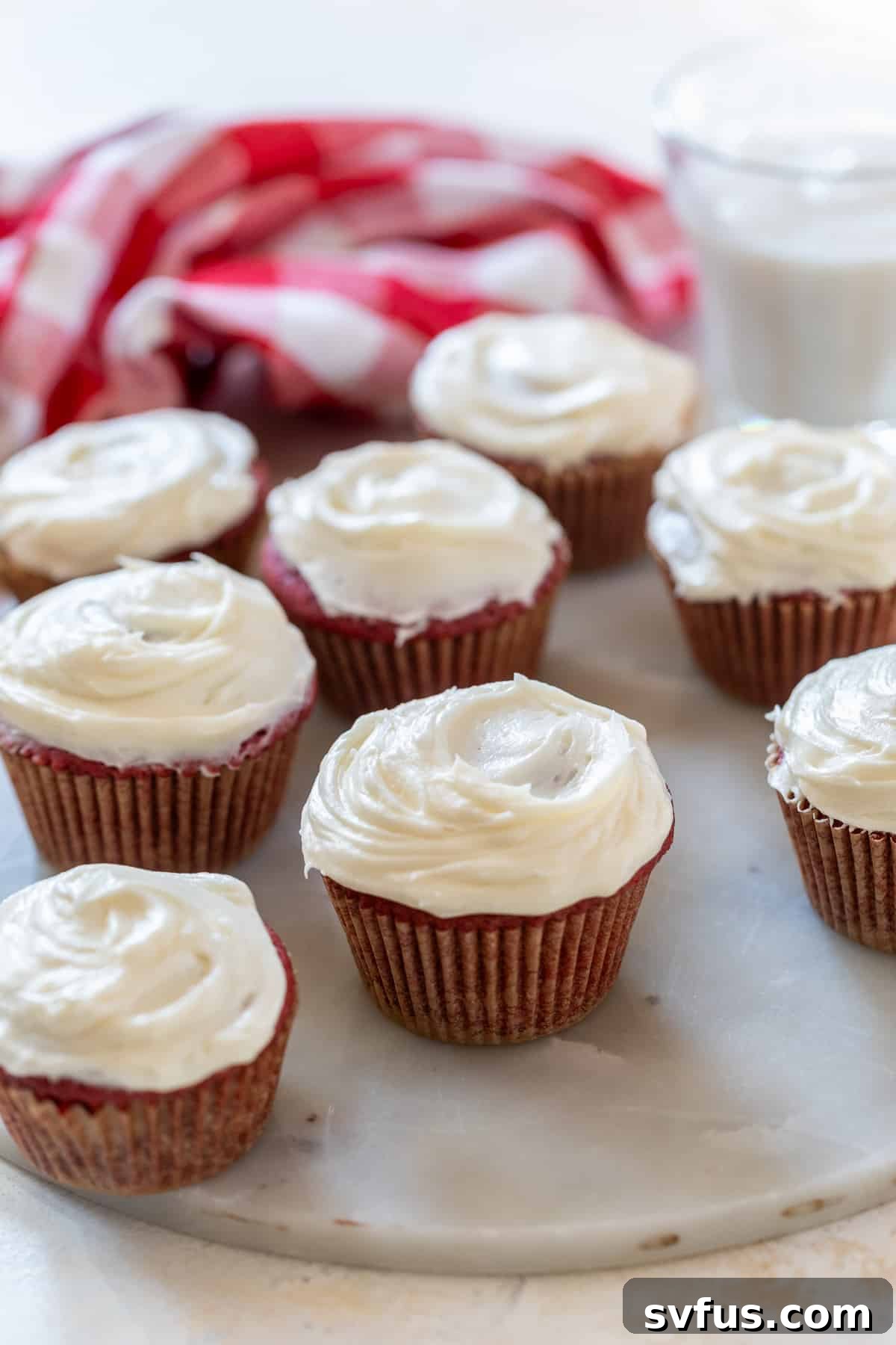 Beautifully frosted red velvet cupcakes arranged on a white plate, ready to be enjoyed.