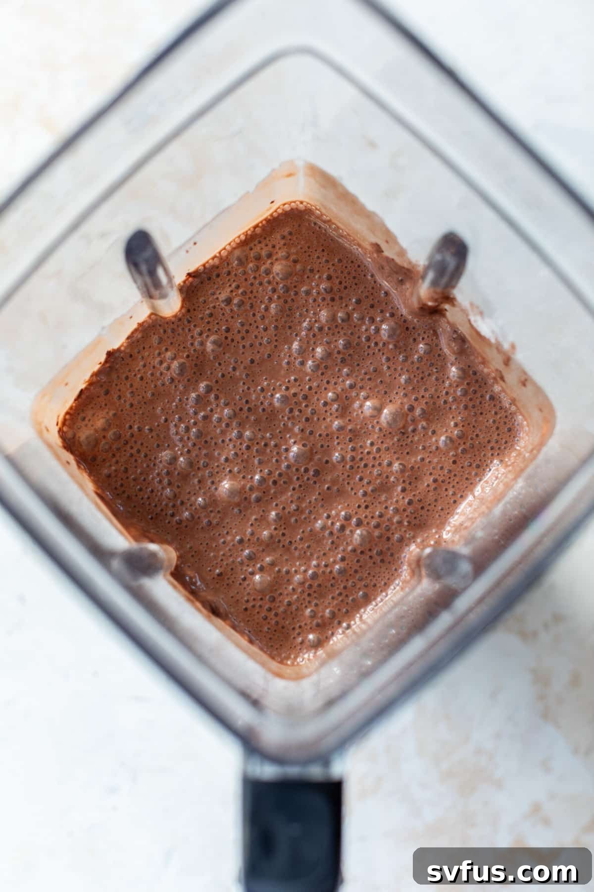 smooth chocolate crepe batter mixed together in a blender, ready for chilling