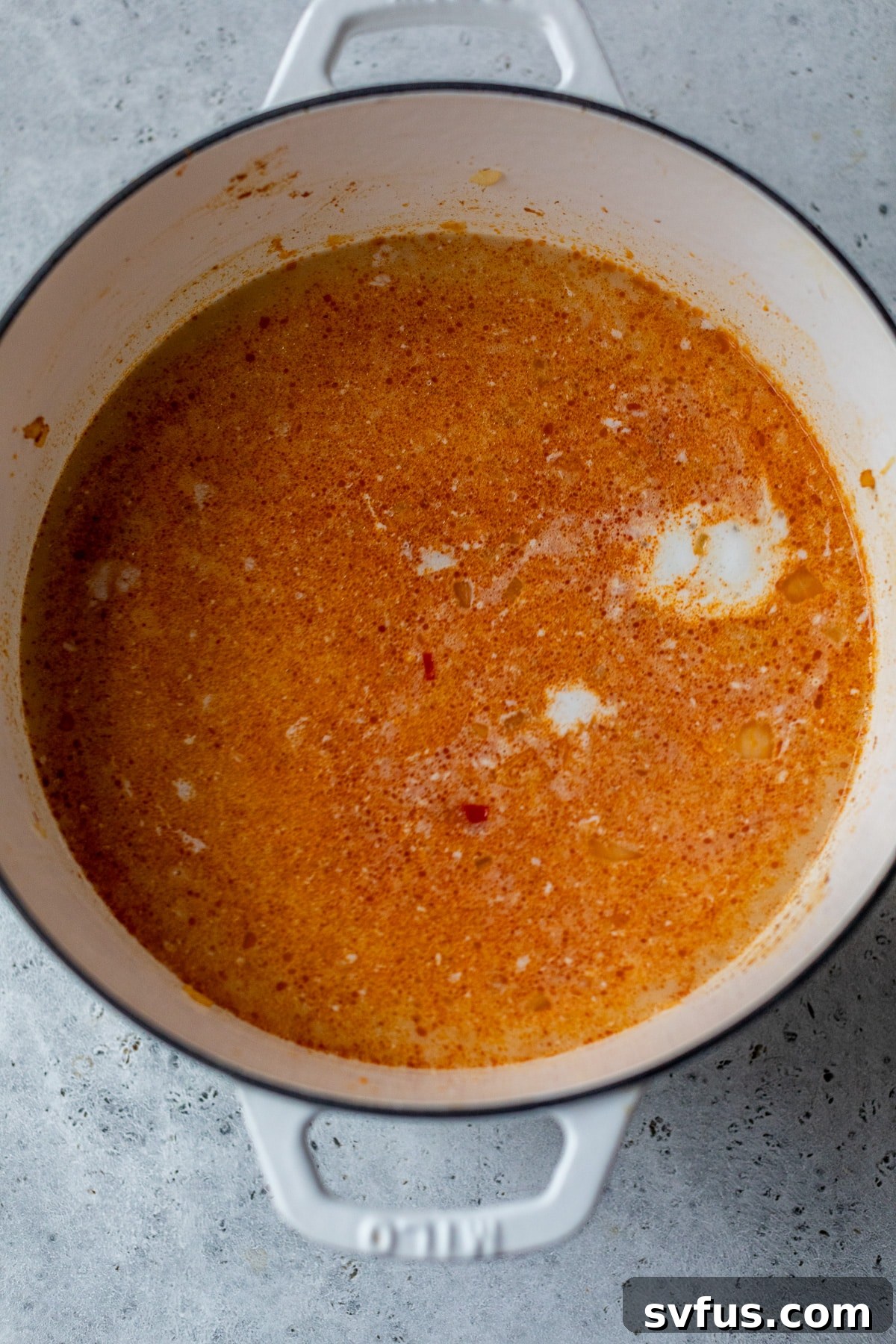 coconut milk added to the dutch oven with broth and vegetables