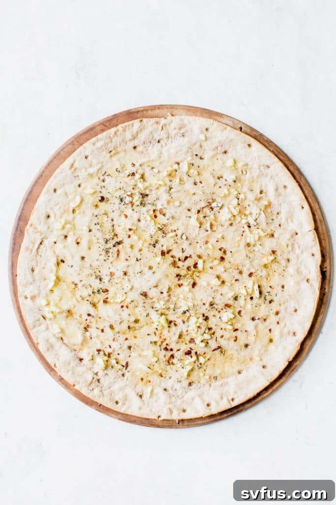 Close-up of thin crust veggie pizza with fresh zucchini ribbons and melted cheese
