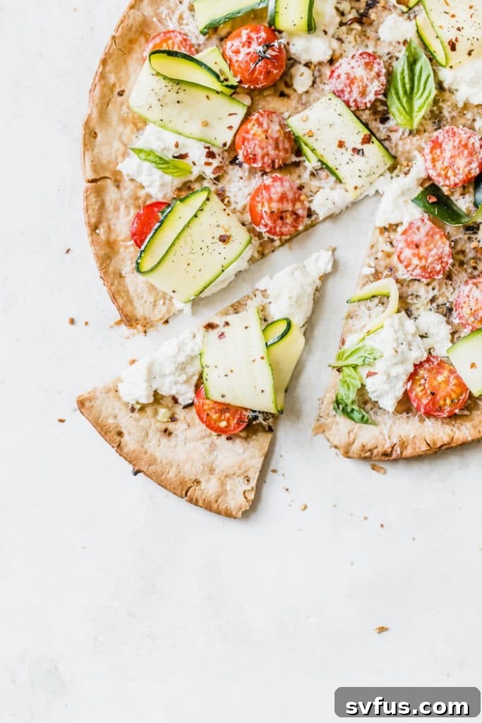 A 20 minute homemade veggie pizza recipe being served on a cutting board, garnished with fresh herbs