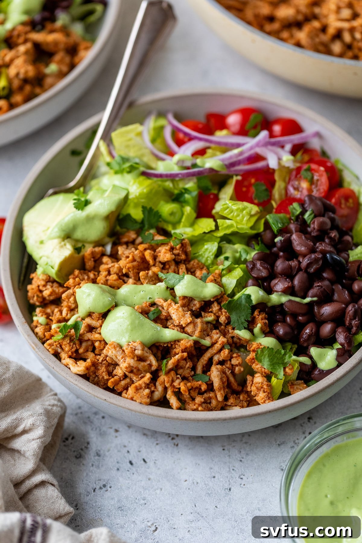 A close-up of a Southwest Chicken Bowl with a fork, emphasizing its fresh ingredients.