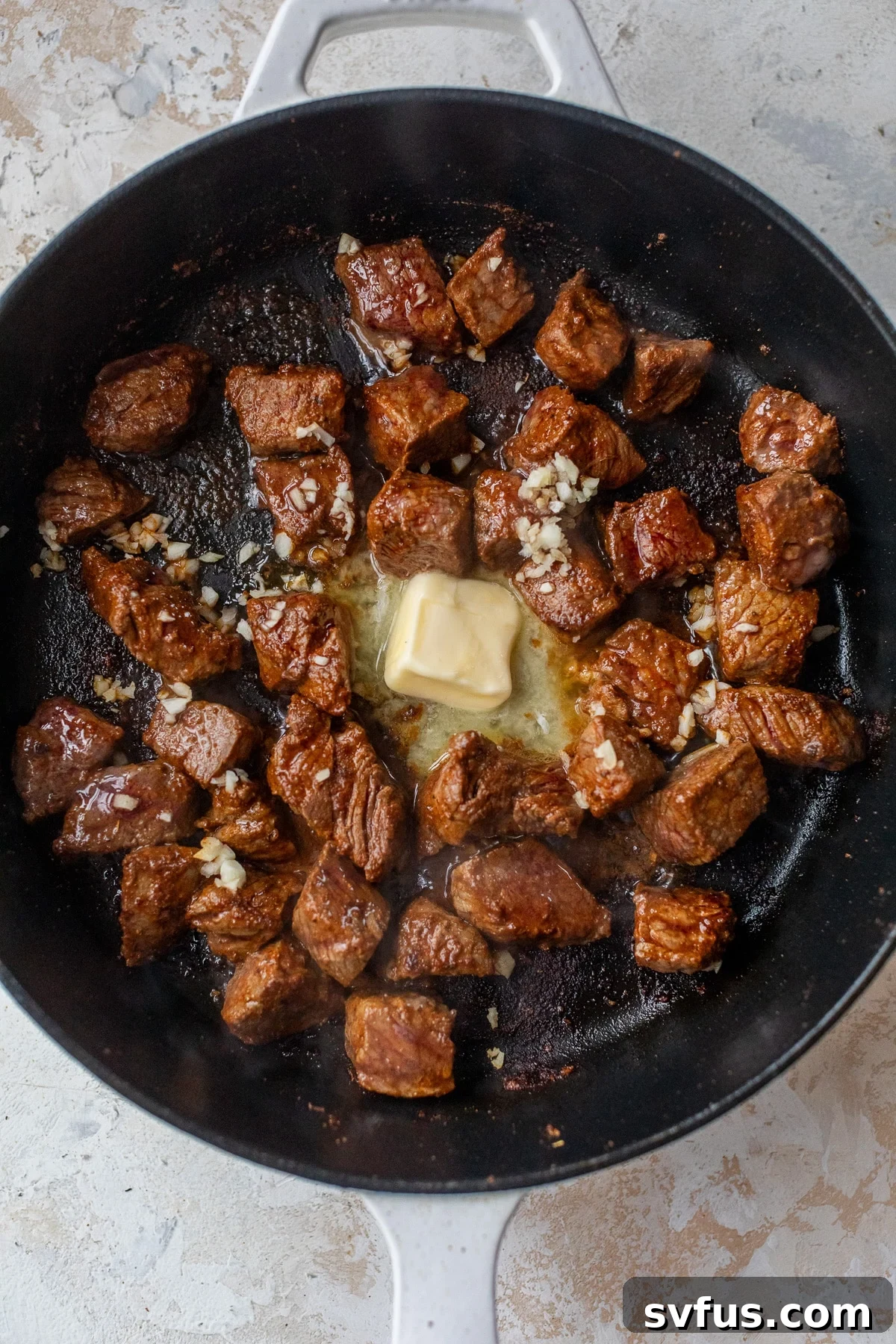 Finished Cajun Steak Bites in a skillet, glistening with melted garlic butter, ready for serving.
