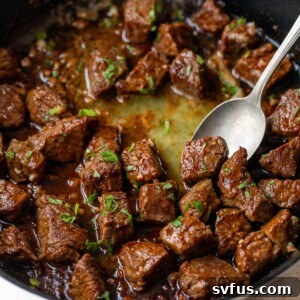 cajun steak bites in a skillet with a spoon