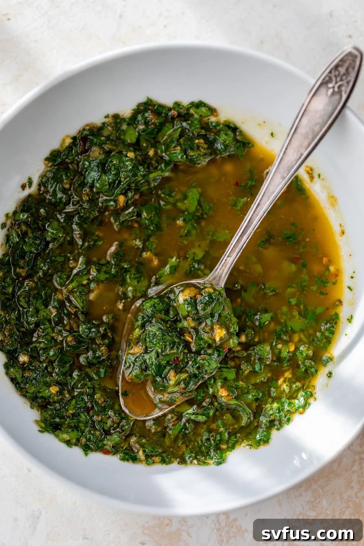 homemade chimichurri sauce in a bowl with a spoon