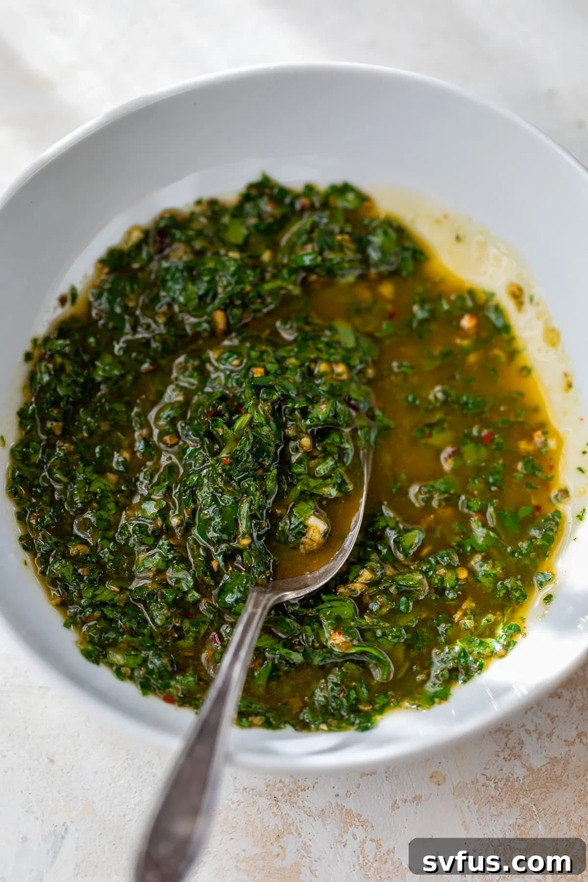 homemade chimichurri sauce in a bowl with a spoon