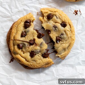 A single-serve chocolate chip cookie split in half, showcasing its gooey center.